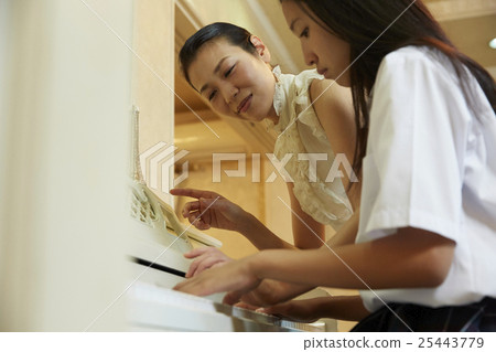 School girls playing the piano 25443779