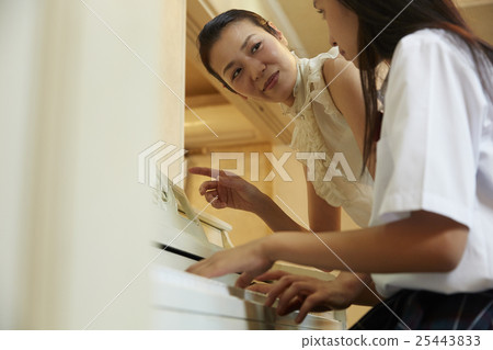 School girls playing the piano School girls playing the piano 25443833