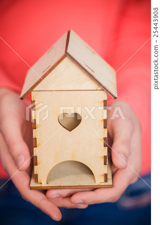 Women's hands with a wooden house 25443908
