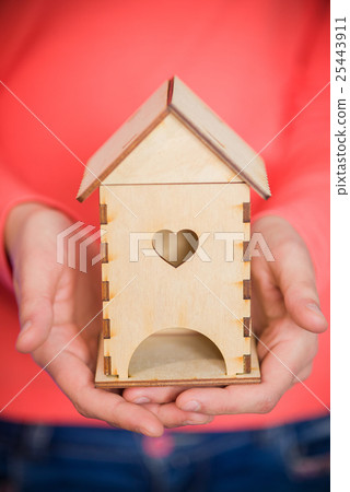 Women's hands with a wooden house Women's hands with a wooden house 25443911
