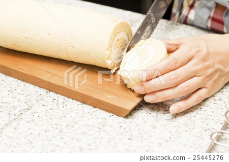 婦女手切割手工製作的捲蛋糕 25445276