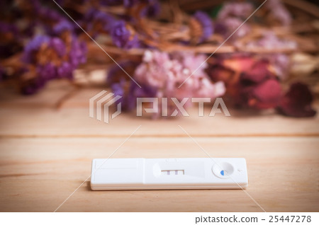 pregnancy test and dried flowers on wooden 25447278