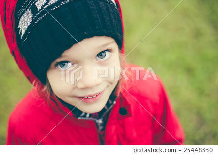 cute girl in a jacket and hat on the stree 25448330