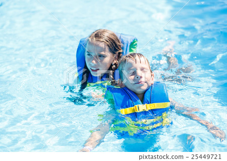 Boy and girl floating in water with life vest Boy and girl floating in water with life vest 25449721