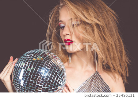 Woman with fashion makeup holding disco ball Woman with fashion makeup holding disco ball 25456131
