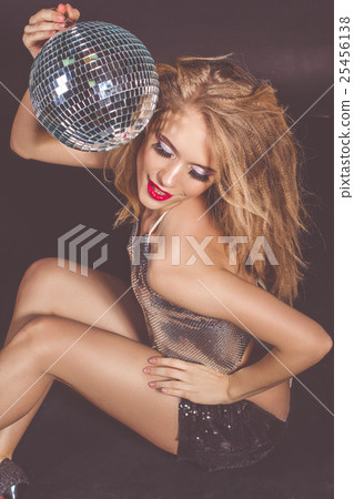 Woman with fashion makeup holding disco ball 25456138