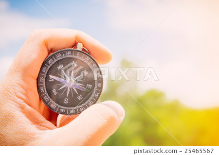 Compass in the hand on the nature background. Compass in the hand on the nature background. 25465567