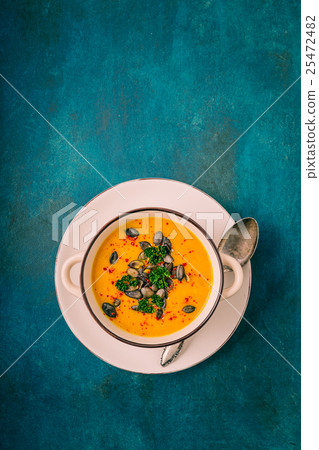 Pumpkin soup with pumpkin seeds and chili peppers 25472482