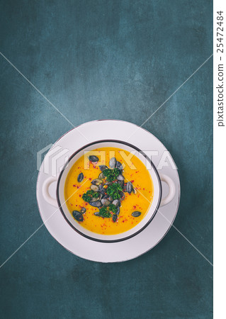 Pumpkin soup with pumpkin seeds and chili peppers 25472484