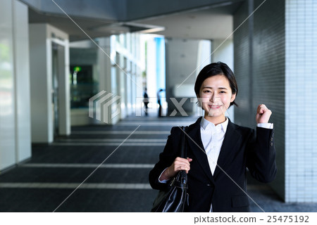 在現代企業圖像大廈前面擺在膽量的公司僱員的女性女商人 在現代企業圖像大廈前面擺在膽量的公司僱員的女性女商人 25475192
