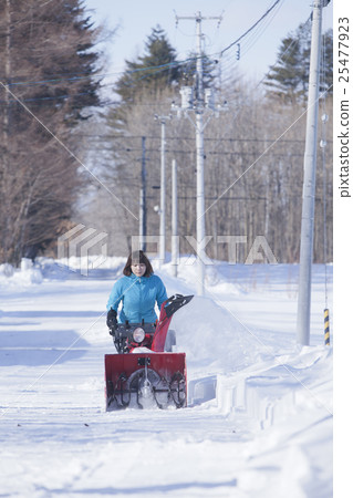 A woman snow removing A woman snow removing 25477923