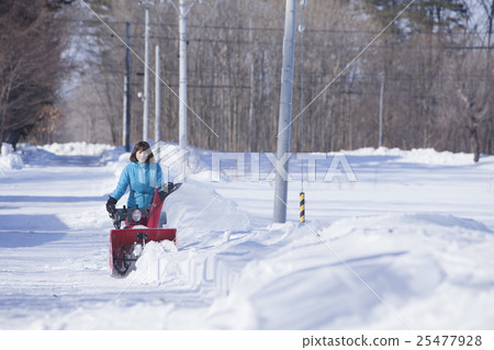 A woman snow removing A woman snow removing 25477928