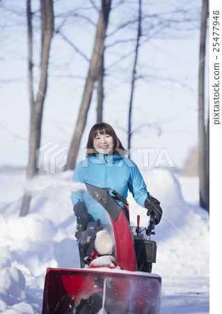 A woman snow removing A woman snow removing 25477948