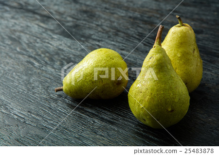 Three green pear on a black background Three green pear on a black background 25483878