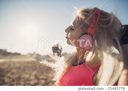 Portrait of young beautiful woman listening to Portrait of young beautiful woman listening to 25485776