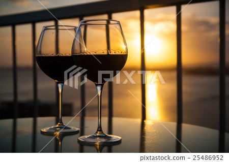 Two glasses with red wine in sunset 25486952