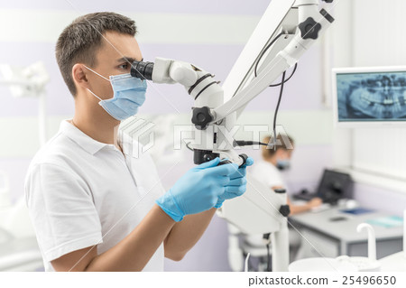 Dentist using dental microscope 25496650