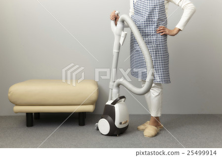 A woman cleaning a vacuum cleaner A woman cleaning a vacuum cleaner 25499914