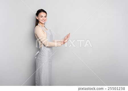 Cheerful woman holding hand in front of her Cheerful woman holding hand in front of her 25501238