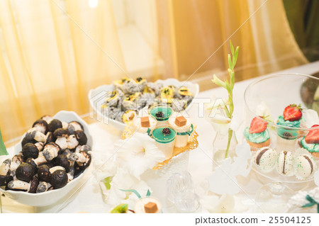 Delicious and tasty dessert table with cupcakes Delicious and tasty dessert table with cupcakes 25504125