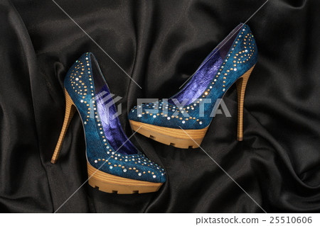 High-heeled shoes  lying on black  fabric 25510606