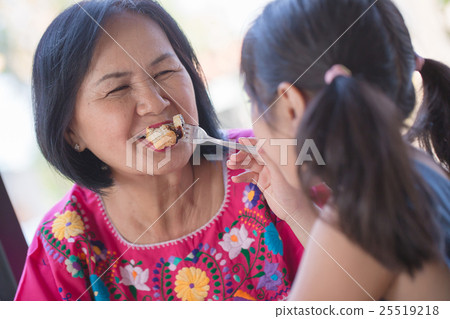 Happy Asian girl feeding honey toast for grandma 25519218