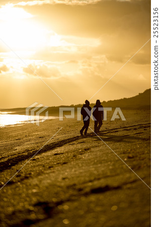 man and woman silhouette on beach at sunrise 25523156
