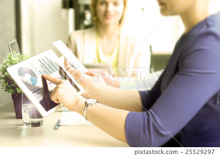 Business colleagues working and analyzing graphs Business colleagues working and analyzing graphs 25529297