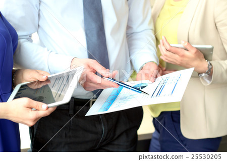 Business colleagues working and analyzing graphs Business colleagues working and analyzing graphs 25530205