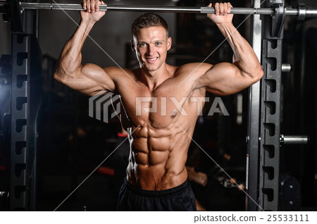 Strong athletic man fitness model showing six pack abs Strong athletic man fitness model showing six pack abs 25533111