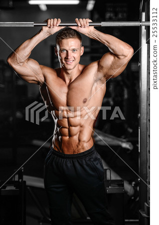 Strong athletic man fitness model showing six pack abs Strong athletic man fitness model showing six pack abs 25533112