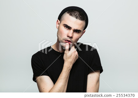 Studio portrait of man with hand on chin Studio portrait of man with hand on chin 25534370