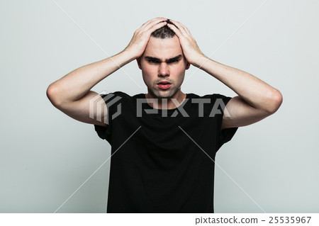 Worrying man posing at studio with arm on head 25535967