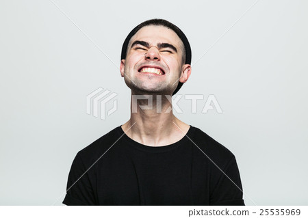 Man feeling exquisite pain while grinning 25535969