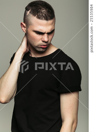 Man in black t-shirt holding his neck Man in black t-shirt holding his neck 25535984
