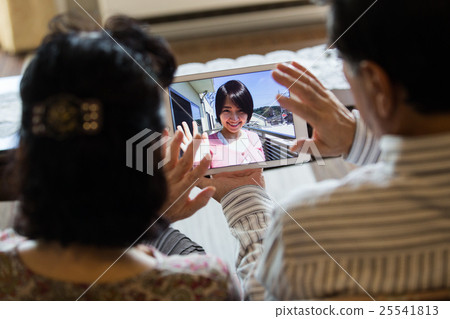 一對老夫妻在平板電腦上享受孫子和Skype 25541813