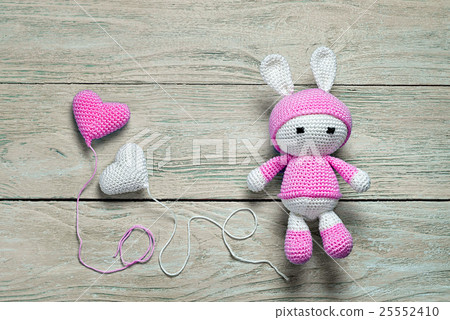 crochet bunny toy on a wooden background  25552410