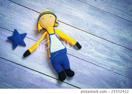 Handsome boy doll on blue wooden boards. 25552412
