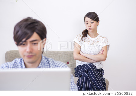 A man playing a personal computer and a woman from behind A man playing a personal computer and a woman from behind 25560852
