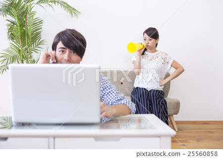 A man playing a personal computer and a woman from behind A man playing a personal computer and a woman from behind 25560858