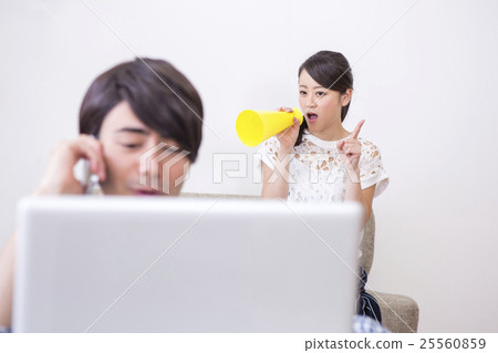 A man playing a personal computer and a woman from behind A man playing a personal computer and a woman from behind 25560859