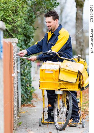 Postman delivering letters to mailbox of recipient 25564242