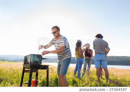 Clique of young people making BBQ at lake 25564597