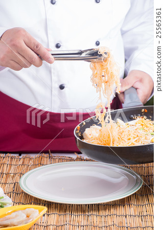 Chef fork over noodles by tongs Chef fork over noodles by tongs 25565361