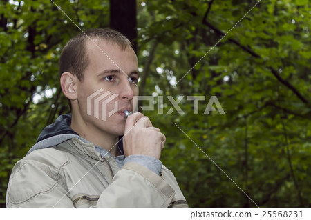 Man smoking electronic sigarette outdoor Man smoking electronic sigarette outdoor 25568231
