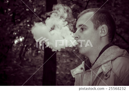 Man smoking electronic sigarette outdoor Man smoking electronic sigarette outdoor 25568232