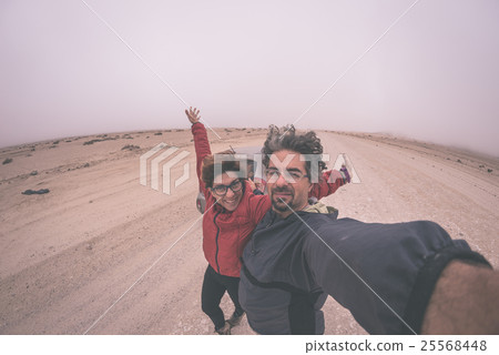 Adult couple taking selfie on gravel road Adult couple taking selfie on gravel road 25568448