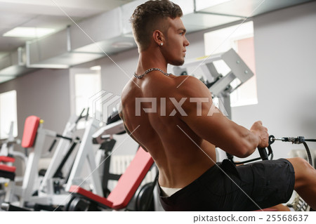 Back view of muscular man trains on simulator Back view of muscular man trains on simulator 25568637