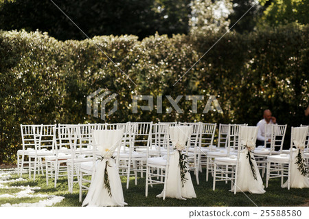 White chairs covered with white cloth stand White chairs covered with white cloth stand 25588580
