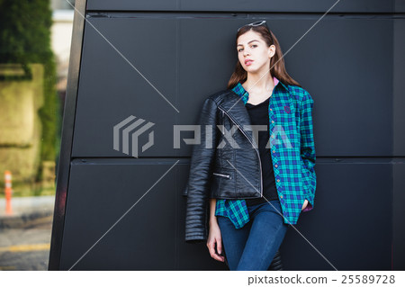 Portrait of brunette girl wearing leather jacket 25589728
